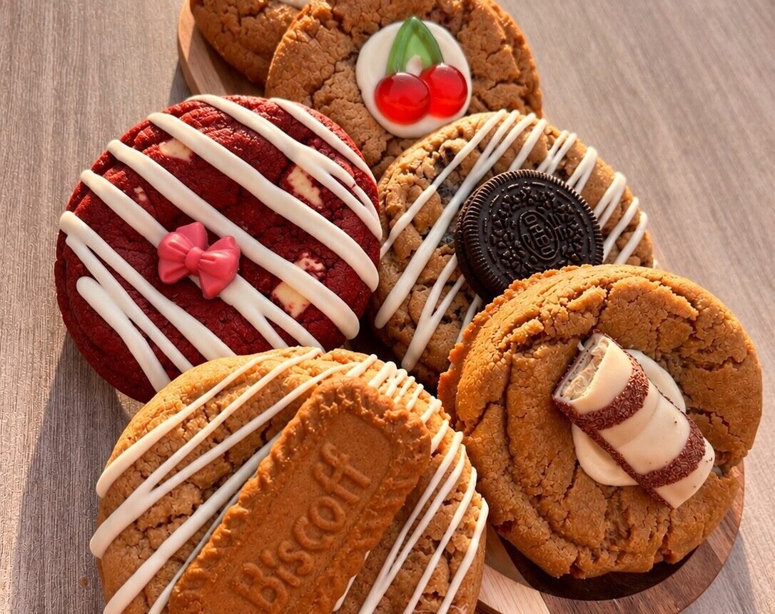 Verschillende gedecoreerde cookies van Kim’s Koekhuisje op een houten plank