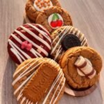 Zes gedecoreerde American cookies van Kim’s Koekhuisje op een houten plank
