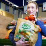 Een Lidl-medewerker bij de groente- en fruitafdeling; illustratieve bedrijfsfoto