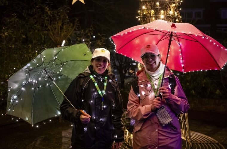 Twee deelnemers met verlichte paraplu’s tijdens een eerdere Light Walk